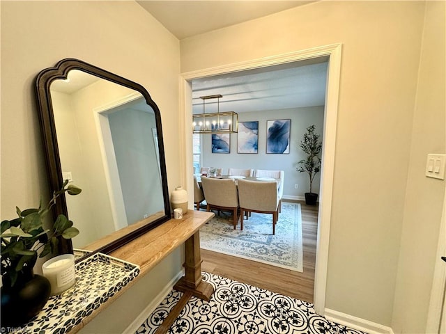 hallway featuring hardwood / wood-style floors and a notable chandelier