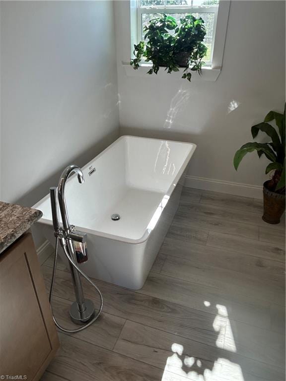 3700 Ireland Rd, Yadkinville, NC 27011 - full bath featuring baseboards, a freestanding bath, vanity, and wood finished floors