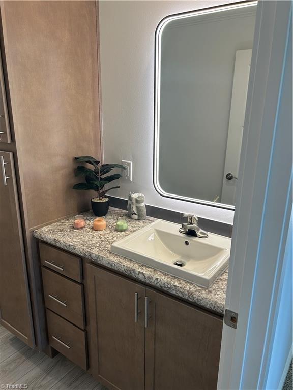 3700 Ireland Rd, Yadkinville, NC 27011 - bathroom with vanity and wood finished floors
