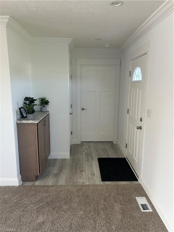 3700 Ireland Rd, Yadkinville, NC 27011 - entrance foyer featuring light wood-style floors, crown molding, and baseboards