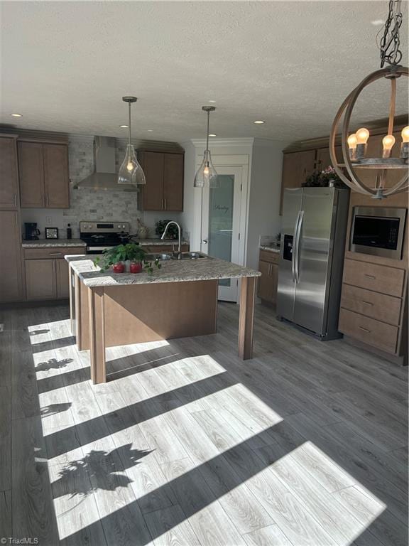 3700 Ireland Rd, Yadkinville, NC 27011 - kitchen featuring appliances with stainless steel finishes, wall chimney exhaust hood, a sink, an island with sink, and a textured ceiling