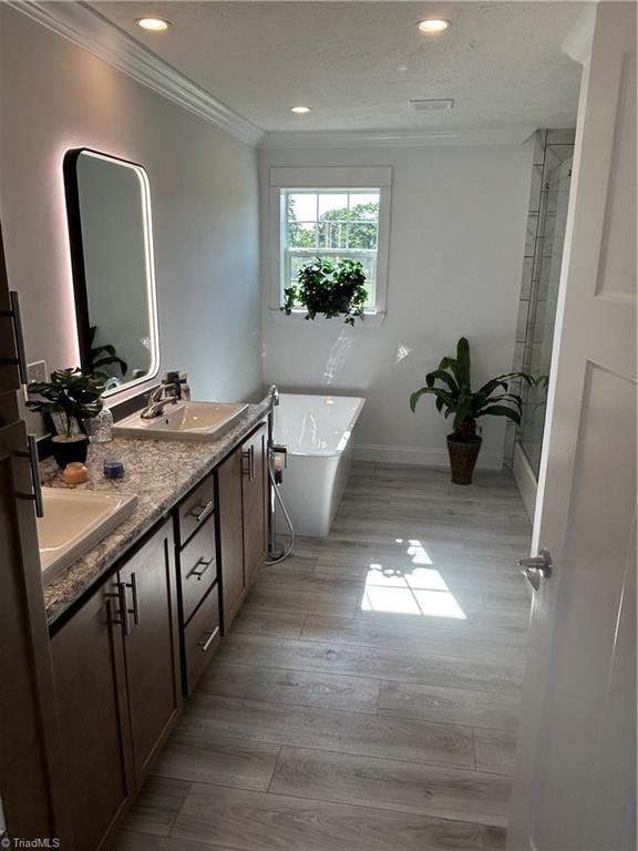 3700 Ireland Rd, Yadkinville, NC 27011 - full bath featuring ornamental molding, a freestanding bath, wood finished floors, double vanity, and recessed lighting