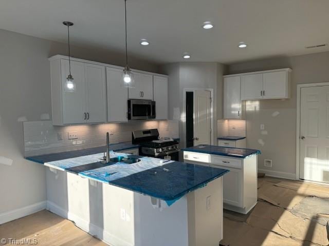 kitchen featuring white cabinetry, stainless steel appliances, sink, and pendant lighting