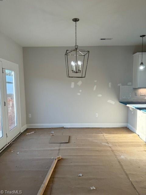 unfurnished dining area featuring an inviting chandelier