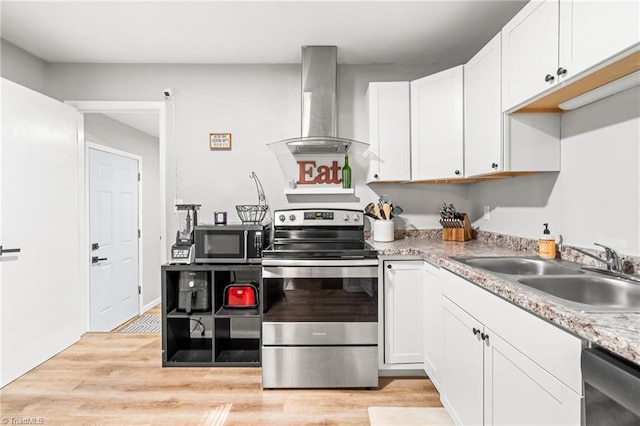 1126 E Springfield Rd, High Point, NC 27263 - kitchen with stainless steel appliances, wall chimney range hood, a sink, and white cabinetry