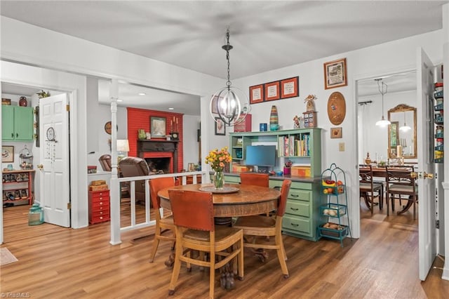 dining area featuring wood finished floors and a brick fireplace