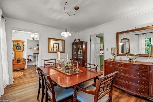 dining room with crown molding, wood finished floors, and a chandelier
