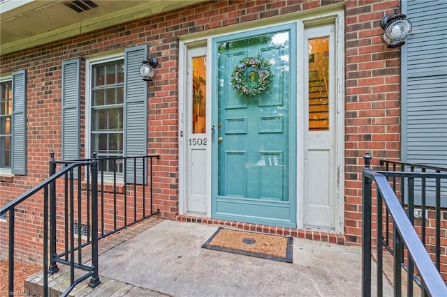 doorway to property featuring brick siding
