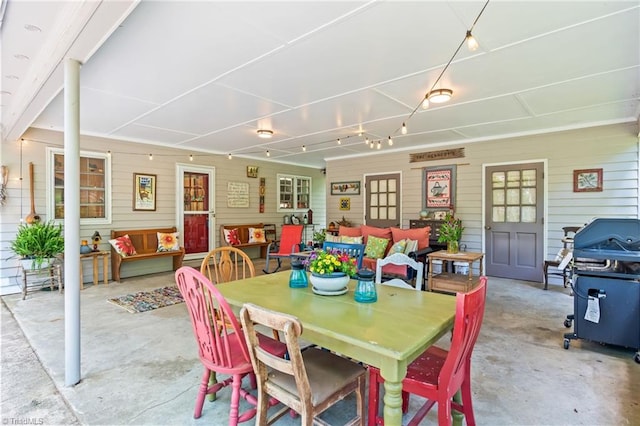 dining area with unfinished concrete flooring and wood walls