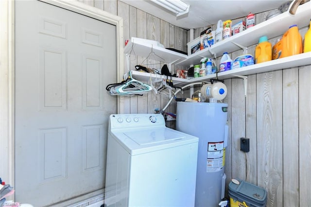 laundry room featuring washer / clothes dryer, wood walls, and water heater