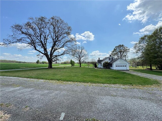 2121/2117 Swan Creek Rd, Jonesville, NC 28642 - view of front of property with a garage, aphalt driveway, a chimney, and a front lawn