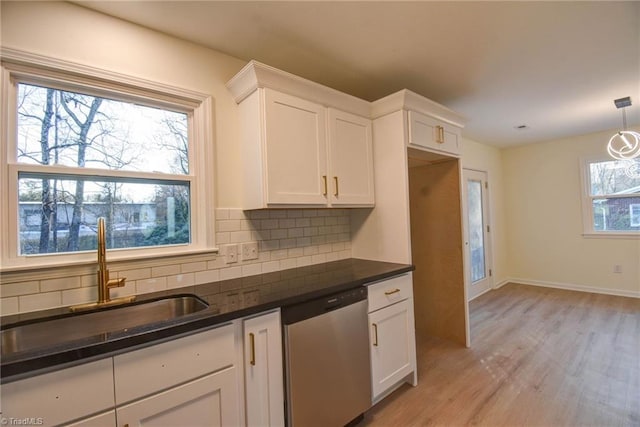 kitchen featuring white cabinetry, decorative light fixtures, dishwasher, and sink