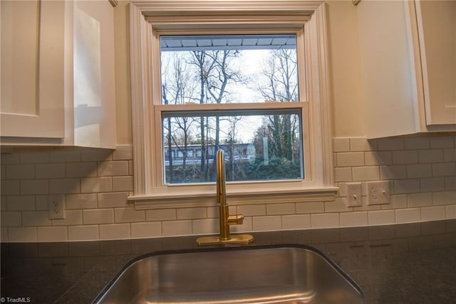 room details with white cabinetry, sink, and tasteful backsplash