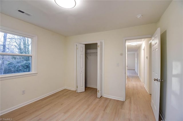 unfurnished bedroom with a closet and light wood-type flooring