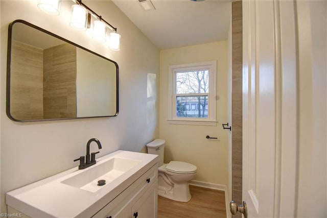 bathroom with vanity, hardwood / wood-style floors, and toilet