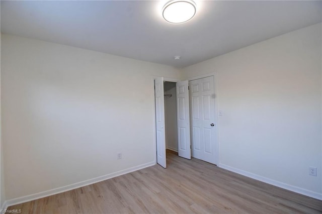 unfurnished bedroom featuring light hardwood / wood-style floors and a closet