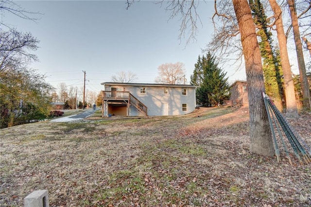 back of house featuring a wooden deck and a yard