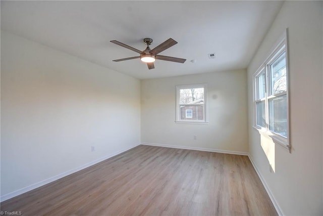 spare room with ceiling fan, a healthy amount of sunlight, and light wood-type flooring