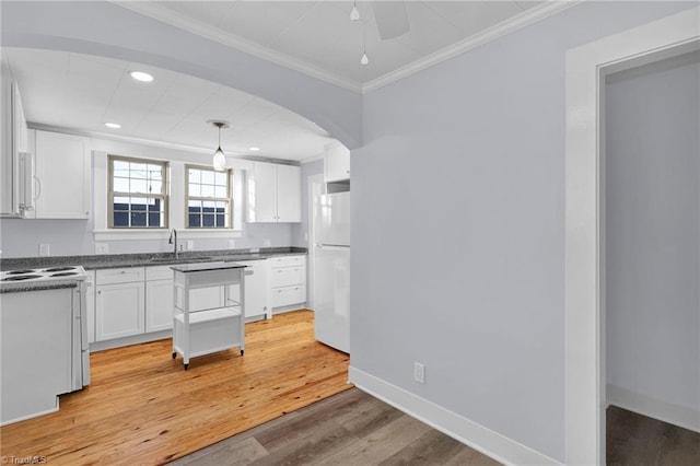 kitchen featuring light wood-type flooring, ornamental molding, white appliances, pendant lighting, and white cabinets