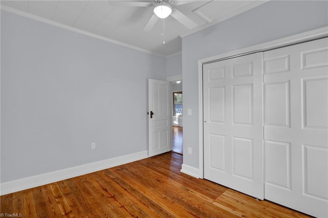 unfurnished bedroom featuring a closet, ceiling fan, hardwood / wood-style floors, and ornamental molding