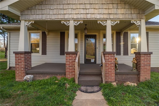 view of exterior entry featuring covered porch