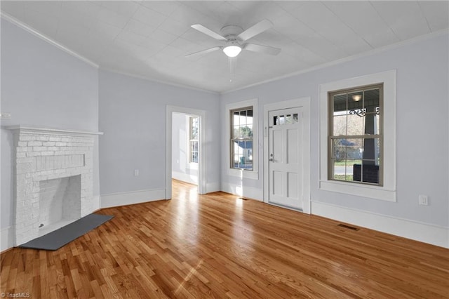 unfurnished living room with a fireplace, hardwood / wood-style flooring, ceiling fan, and crown molding