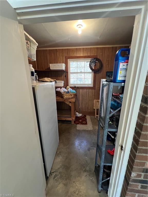 kitchen with concrete flooring and wood walls