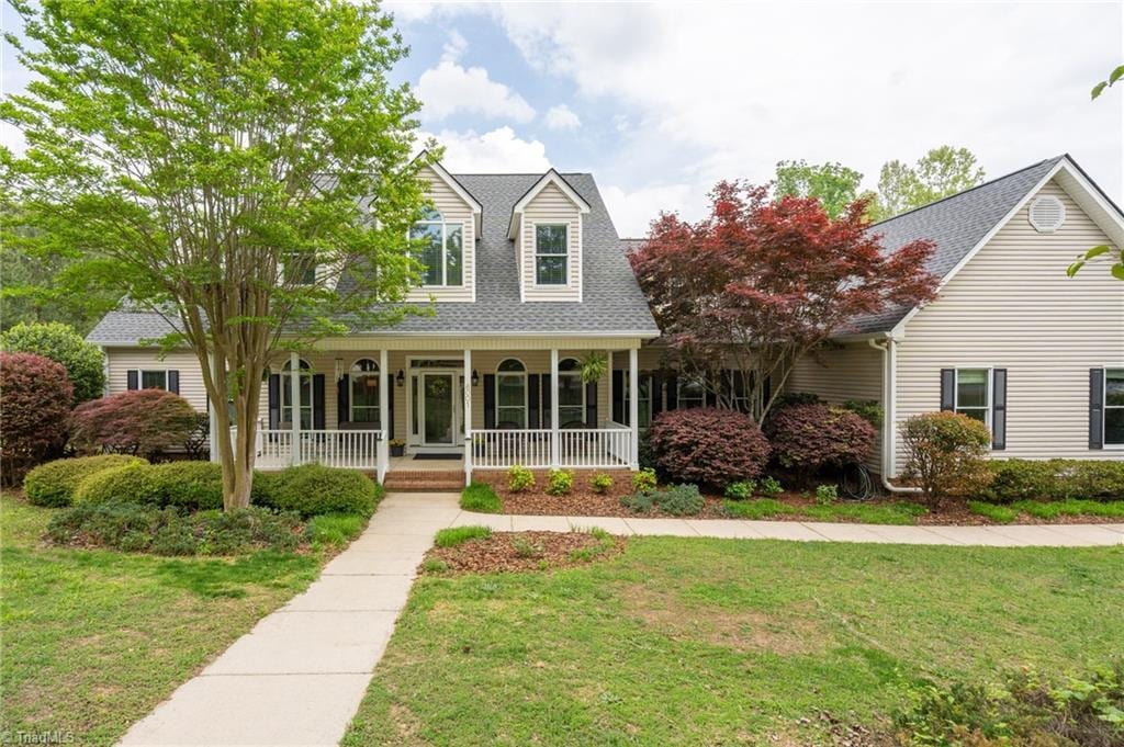 6001 Spring Forest Ct, Pleasant Garden, NC 27313 - cape cod-style house featuring a porch, a front lawn, and a shingled roof