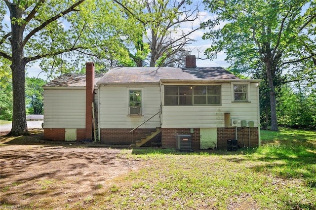 rear view of property featuring a yard and central AC unit