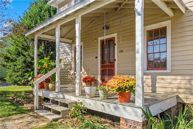 view of exterior entry featuring covered porch