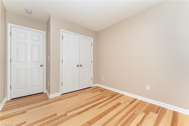 2305 Hartfield Cir, Winston-Salem, NC 27103 - unfurnished bedroom with light wood-style flooring, baseboards, and a closet