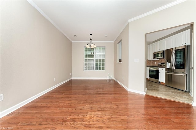 2305 Hartfield Cir, Winston-Salem, NC 27103 - spare room featuring a chandelier, crown molding, light wood-style flooring, and baseboards