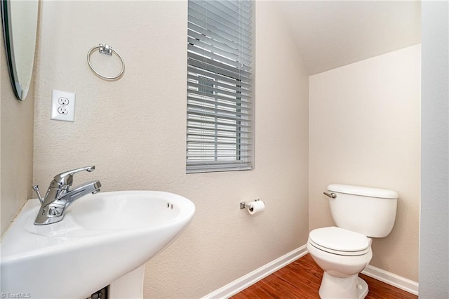 2305 Hartfield Cir, Winston-Salem, NC 27103 - bathroom featuring a sink, wood finished floors, toilet, baseboards, and vaulted ceiling