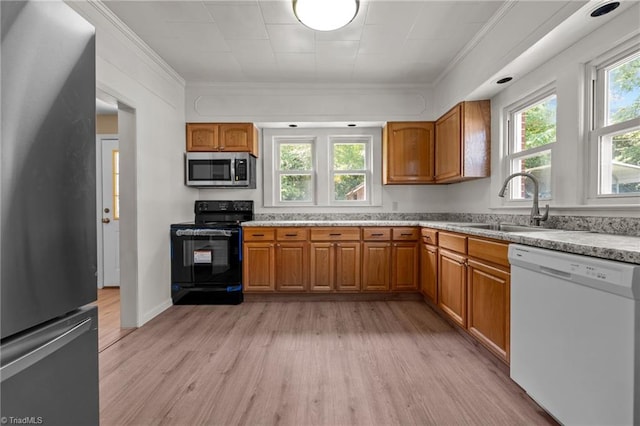 kitchen with stainless steel appliances, sink, crown molding, and light hardwood / wood-style flooring