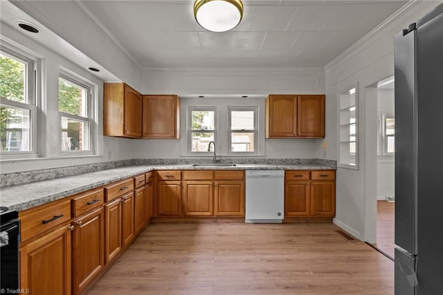 kitchen with white dishwasher, plenty of natural light, sink, and stainless steel fridge