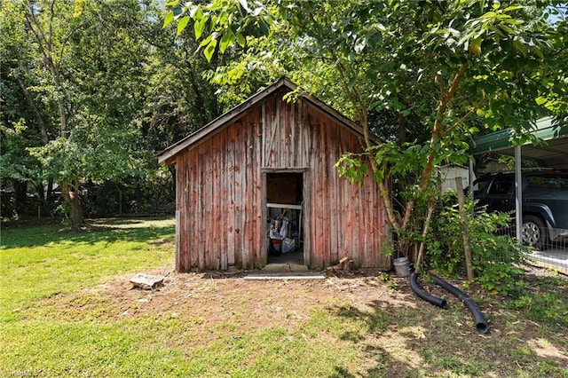 view of outbuilding featuring a yard and a carport