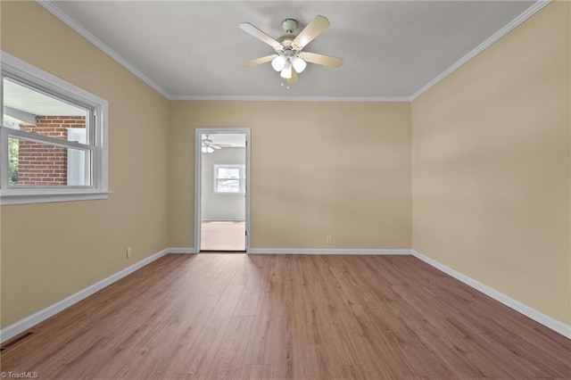 empty room with a healthy amount of sunlight, light hardwood / wood-style flooring, and ceiling fan