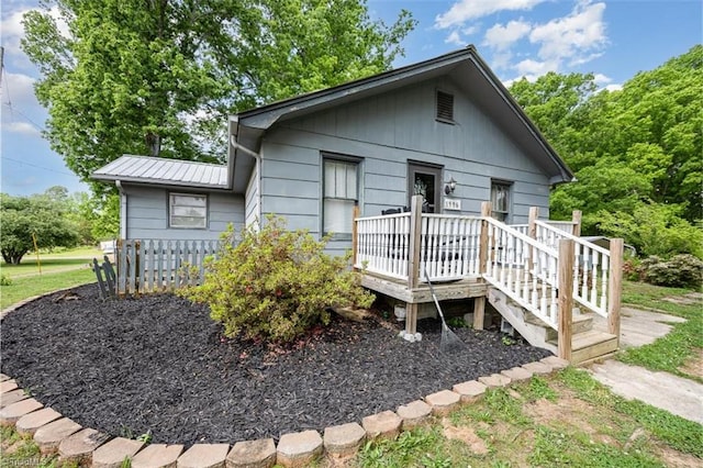 view of front of property with a wooden deck and metal roof