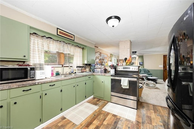 kitchen featuring crown molding, a sink, appliances with stainless steel finishes, light countertops, and light wood-type flooring