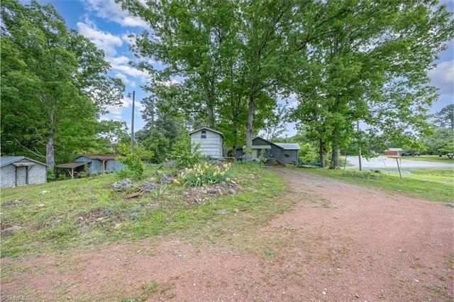 view of front of property featuring an outdoor structure, a shed, and driveway