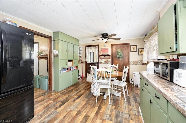 dining room with a healthy amount of sunlight, a ceiling fan, ornamental molding, and dark wood-style floors