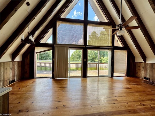 additional living space with ceiling fan, beamed ceiling, wood-type flooring, and high vaulted ceiling