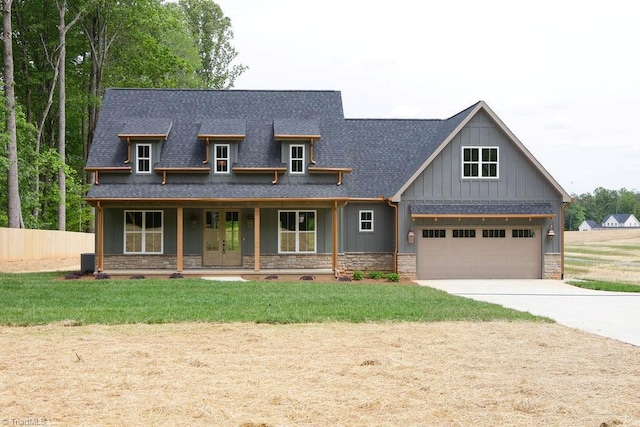 view of front of house with a shingled roof, stone siding, driveway, french doors, and board and batten siding