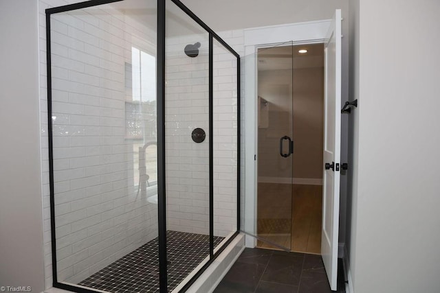 bathroom with a stall shower and marble look tile flooring