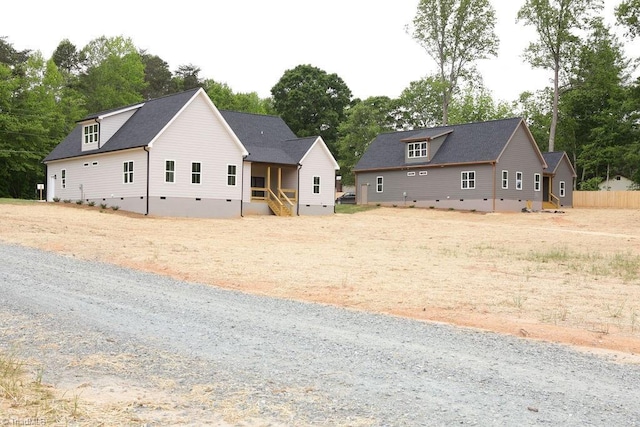 view of front of home featuring crawl space and view of wooded area