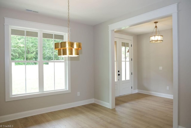 foyer with light wood-style floors, baseboards, and a chandelier