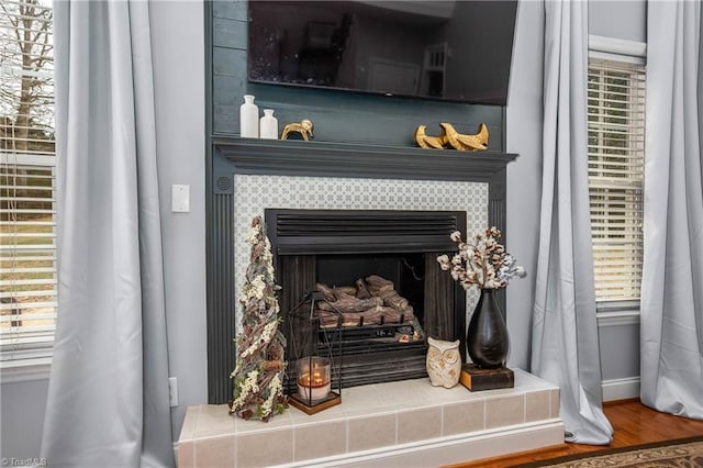 interior details featuring a tile fireplace