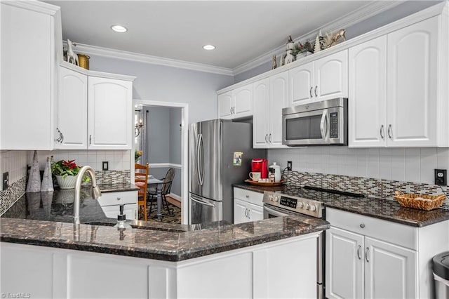 kitchen featuring white cabinets, appliances with stainless steel finishes, and kitchen peninsula