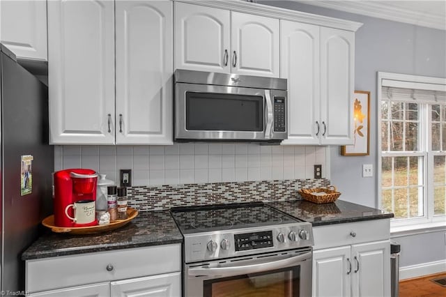 kitchen with white cabinets, tasteful backsplash, and appliances with stainless steel finishes