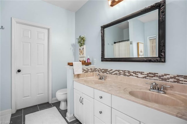 bathroom featuring tile patterned floors, vanity, toilet, and tasteful backsplash